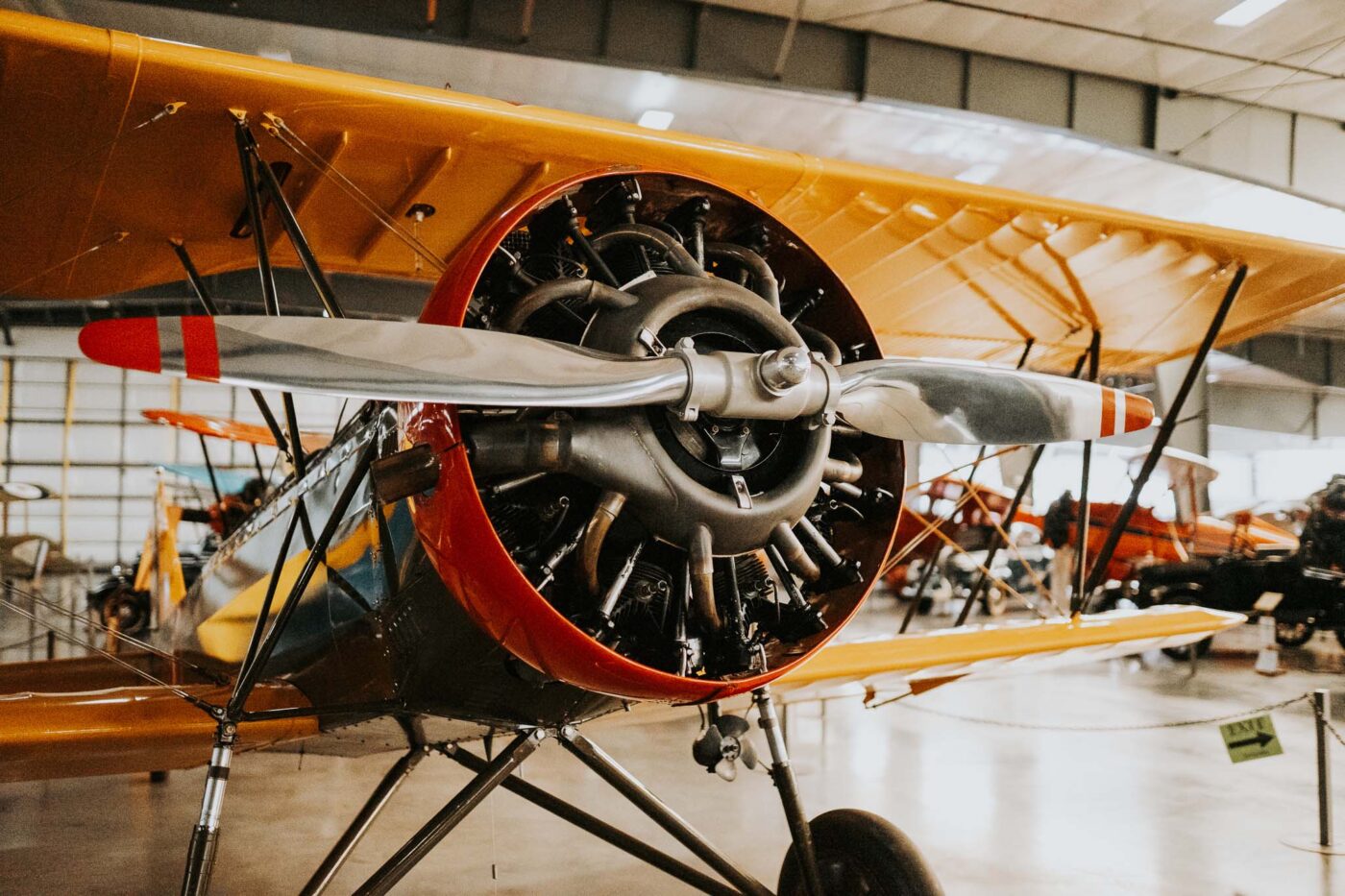 Black and orange biplane in a hanger at the Western Antique Aeroplane & Automobile Museum.